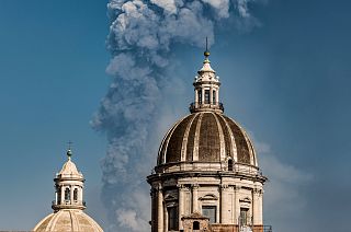 Smoke billows from a crater of Mount Etna volcano behind the dome of the Catania Saint Agatha cathedral in Catania, southern Italy. March 4, 2021.