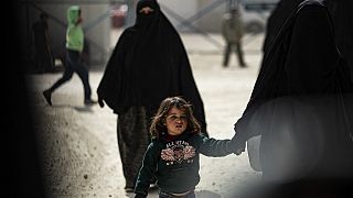 A woman and children are pictured at the Kurdish-run al-Hol camp