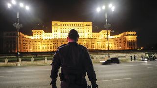 A riot police officer stands outside the Romanian parliament building in Bucharest.