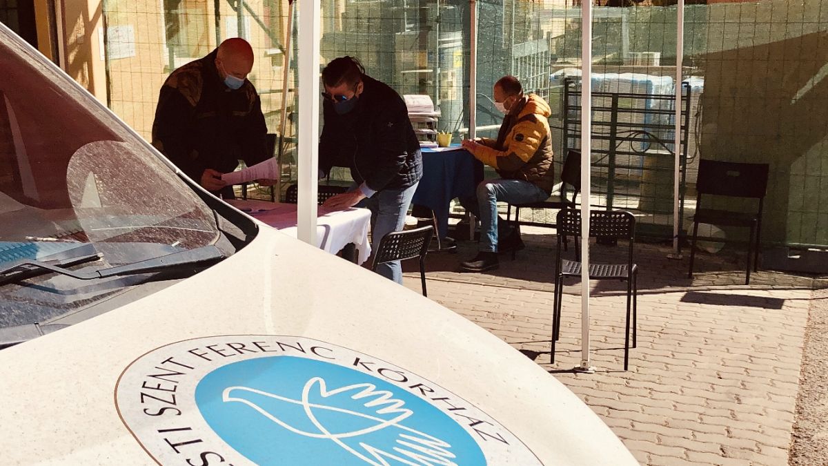 Regisztráció egy kórházi oltópont bejáratánál Budapesten szombaton, a déli órákban