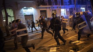 FILE PHOTO: Police officers run during clashes following a protest condemning the arrest of rap singer Pablo Hasel in Barcelona, Spain, Tuesday, Feb. 23, 2021.