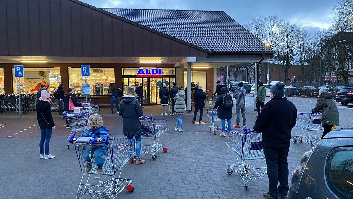 Customers wait for the opening of a branch of the German discounter 'Aldi' in Hamburg, Germany, Saturday, March 6, 2021.