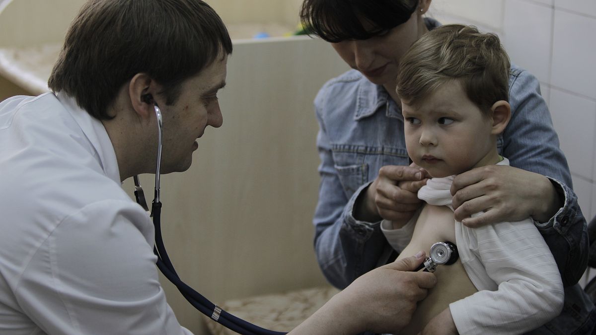 Fjodor Lapij ukrán gyermekorvos vizsgál egy gyereket 2013-ban Kijevben