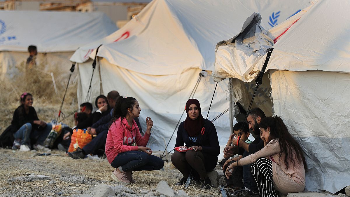 نازحون سوريون من شمال شرق سوريا، ينتظرون استلام الخيام وإمدادات الإغاثة في مخيم بردرش للاجئين شمال الموصل بالعراق.