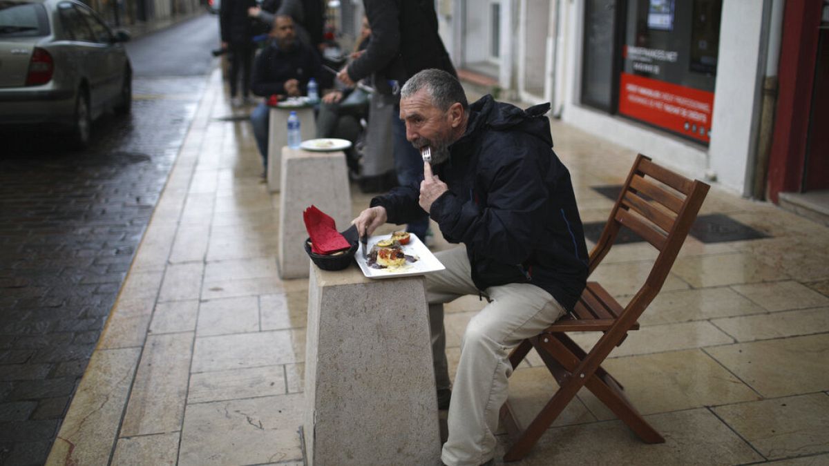 People lunch outside a pizza restaurant in Marignane, southern France, Monday Feb.1, 2021
