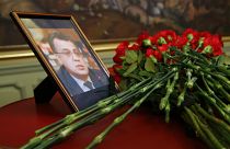 Flowers lay next to a portrait in memory of Russian Ambassador to Turkey, Andrei Karlov.