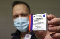 Un farmacista ungherese mostra la confezione del vaccino Sputnik V che inoculerà ai suoi clienti della città di Miskolc