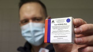 A pharmacist holds a packet of Sputnik V vaccines