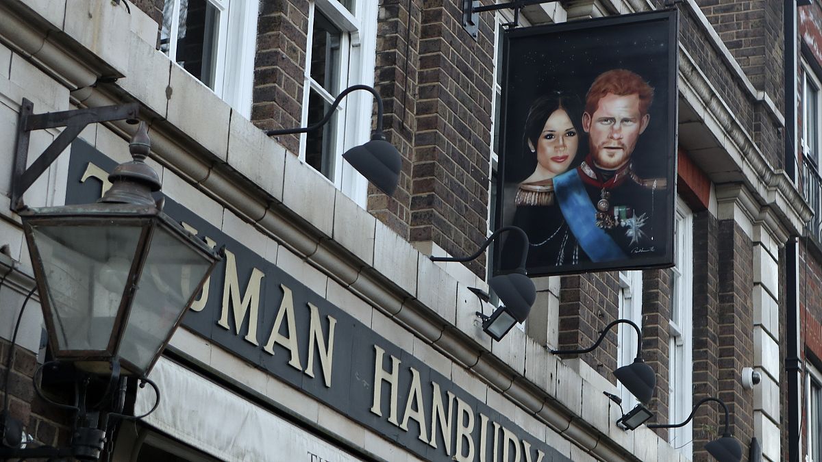 A sign showing Britain's Prince Harry and his wife Meghan, hangs outside the Duke of Sussex pub near Waterloo station, London, Tuesday March 9, 2021