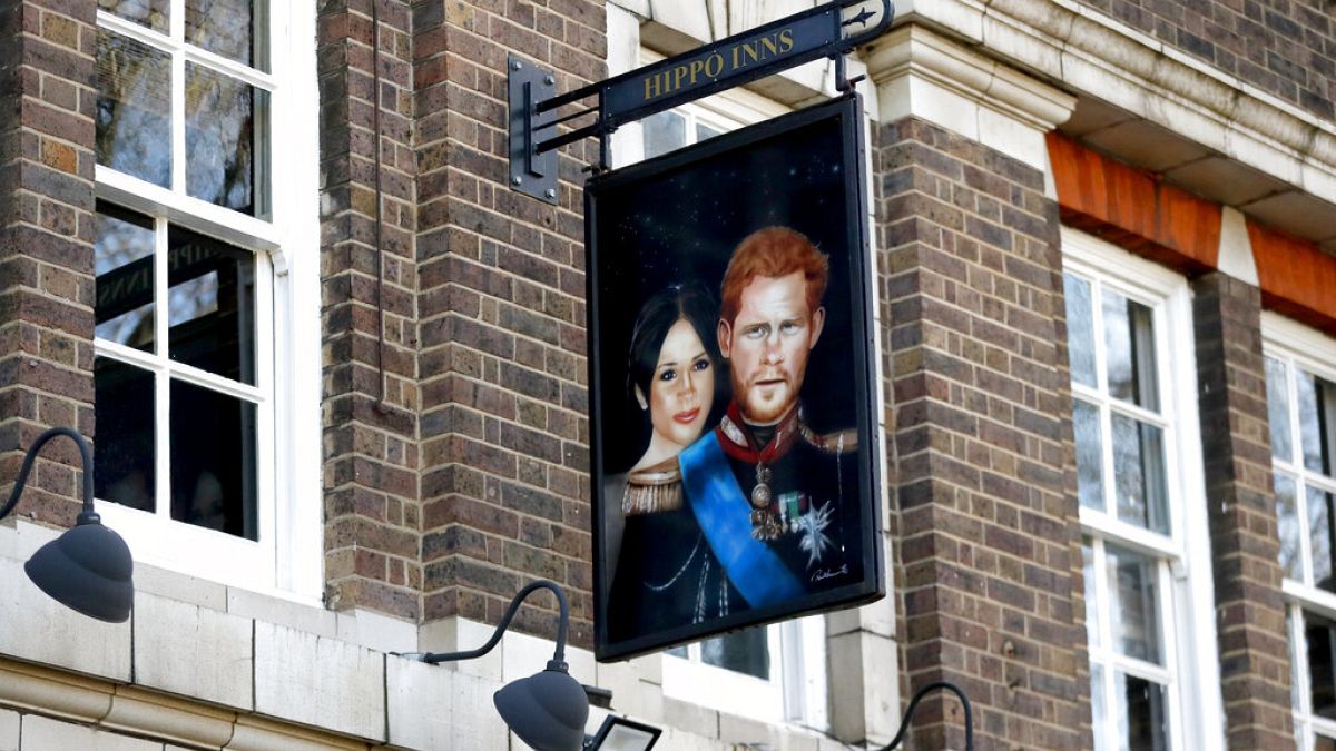 A sign depicting the image of Britain's Prince Harry and his wife Meghan, hangs outside the Duke of Sussex pub near Waterloo station, London, Tuesday March 9,