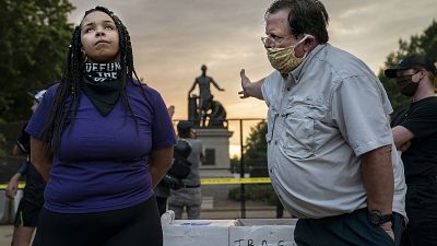 Anais, 26 anni, si batte per la rimozione dell'Emancipation Memorial di Lincoln Park, Washington DC. Accanto a lei, un uomo che la pensa all'opposto