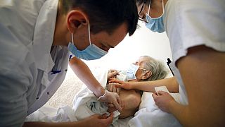 Dr. Cedric Waechter, left, administers the Pfizer-BioNTech COVID-19 vaccine to a resident of the Bois Fleuris nursing home Wednesday, Jan. 6, 2021 in Strasbourg