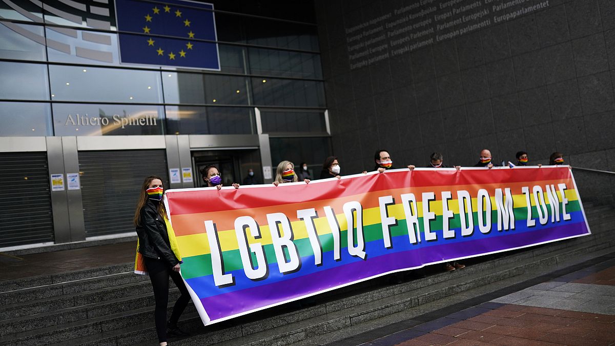 Activists hold a rainbow banner in front of the European Parliament in Brussels on Tuesday ahead of the debate.