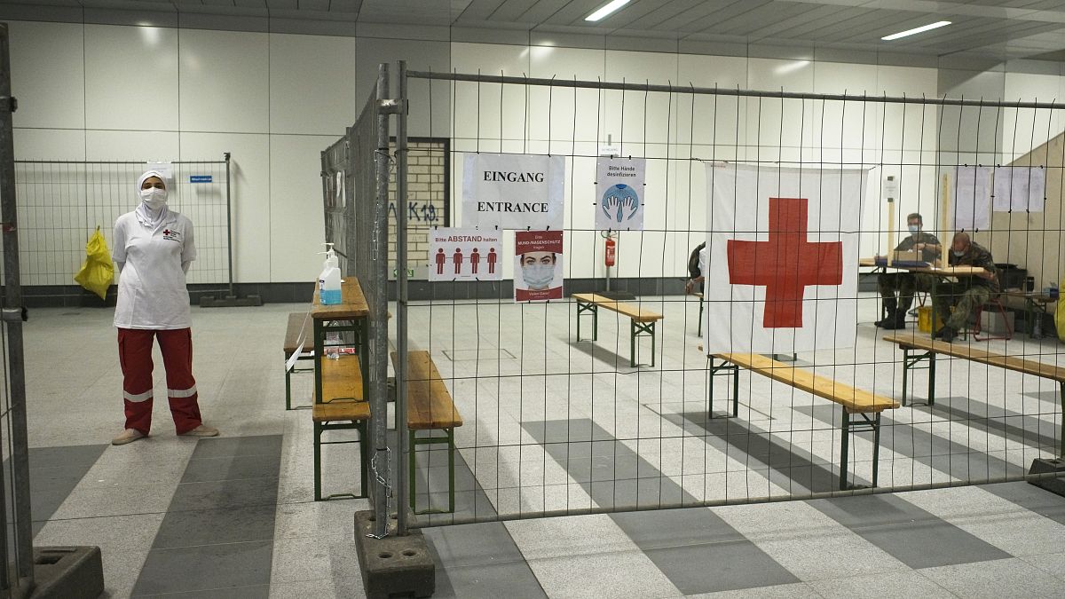أعضاء في الصليب الأحمر الألماني في محطة اختبار فيروس كورونا في محطة القطار الرئيسية في برلين، ألمانيا