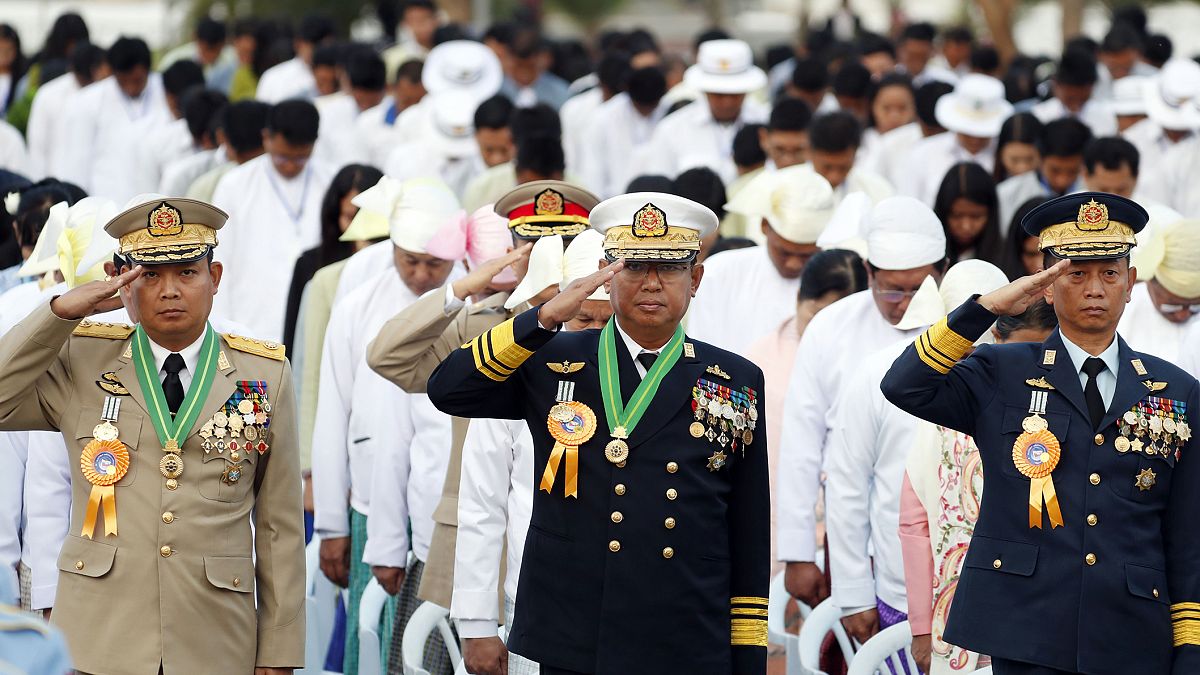Myanmarlı generaller bir programda bayrağa selam verirken