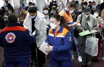 Members of Civil Protection check air travellers documents at Paris Charles de Gaulle airport in Roissy, near Paris, Friday Feb.5, 2021.