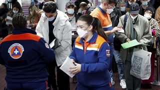 Members of Civil Protection check air travellers documents at Paris Charles de Gaulle airport in Roissy, near Paris, Friday Feb.5, 2021.