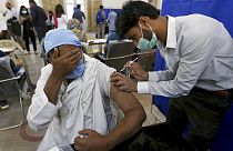 A man reacts while receiving a Sinopharm coronavirus vaccine from a health worker at a vaccination center, in Karachi, Pakistan, Wednesday, March 10, 2021