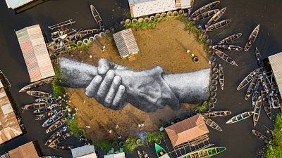 «دست در دست هم دهيم به مهر»؛ اثر هنری بر روی چمن جزیره‌ای آفریقایی
