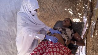 قابلة سودانية تفحص امرأة حامل في عيادة تديرها منظمة أطباء بلا حدود في مخيم أم ركوبة للاجئين في القضارف، شرق السودان - 2020