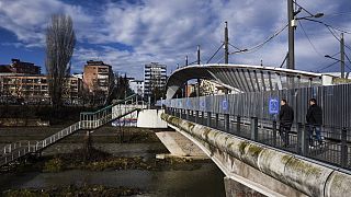 People walk on the main bridge of the town of Mitrovica on February 13, 2016.