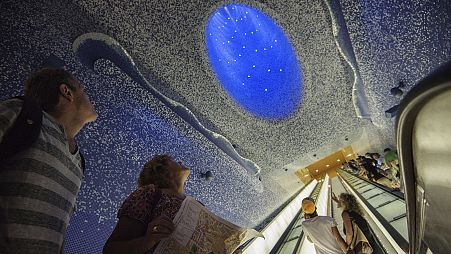 Tourists look at the ceiling of Toledo underground metro station in Naples by Spanish architect Oscar Tousquets Blanca.