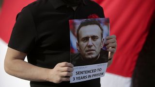 A demonstrator holds a picture of Alexei Navalny during a protest demanding freedom for political prisoners in Lisbon.