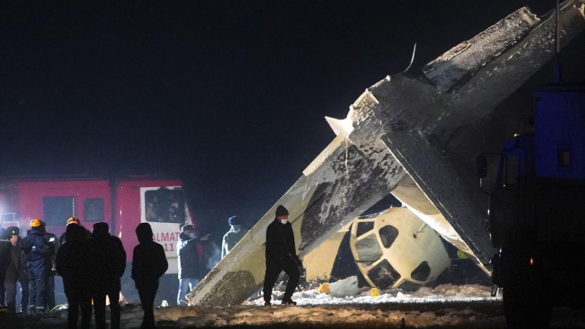 Emergency employees work at the side of the crashed Soviet-built An-26 two-engine turboprop at the airport of Kazakhstan's largest city, Almaty, Kazakhstan.