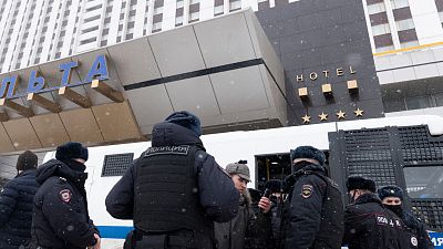 Police officers stand in front of a hotel where participants of a forum of independent members of municipal councils gathered in Moscow, Russia, Saturday, March 13, 2021