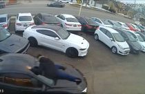 شاهد: لصان يسرقان سيارة فاخرة من متجر والبائع يتشبث بالزجاج الأمامي لوقفهما