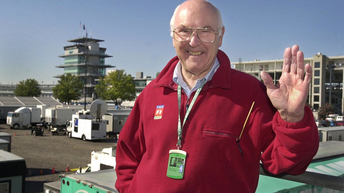 In this Sunday, Sept. 30, 2001 file photo, Legendary Formula 1 race broadcaster Murray Walker poses in the television compound at Indianapolis Motor Speedway.