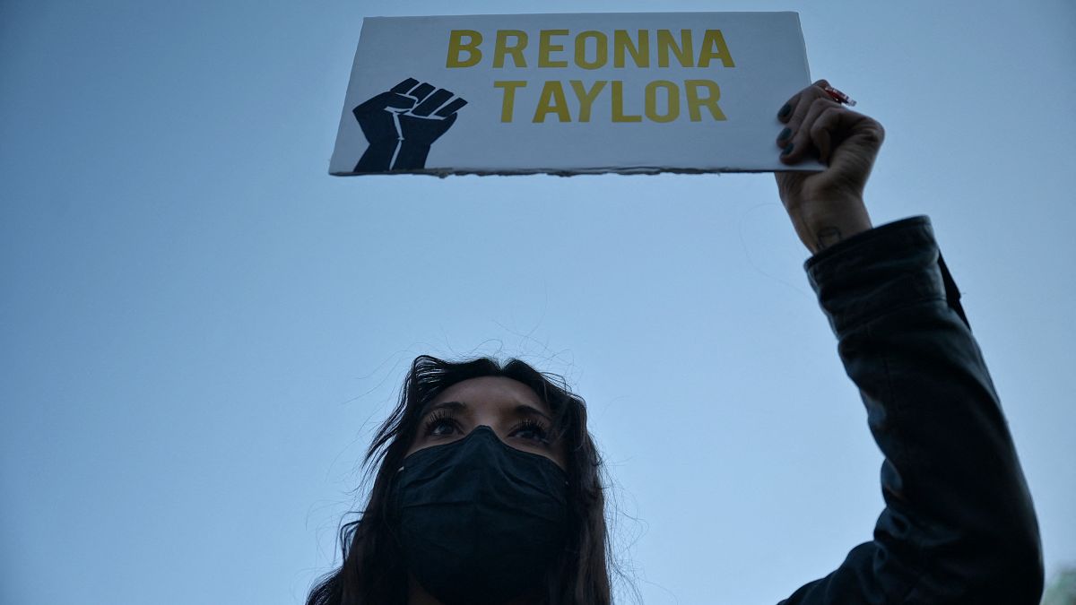 A protestor brandishes a portrait of Breonna Taylor during a rally in remembrance on the one year anniversary of her death in Louisville, Kentucky on March 13, 2021.