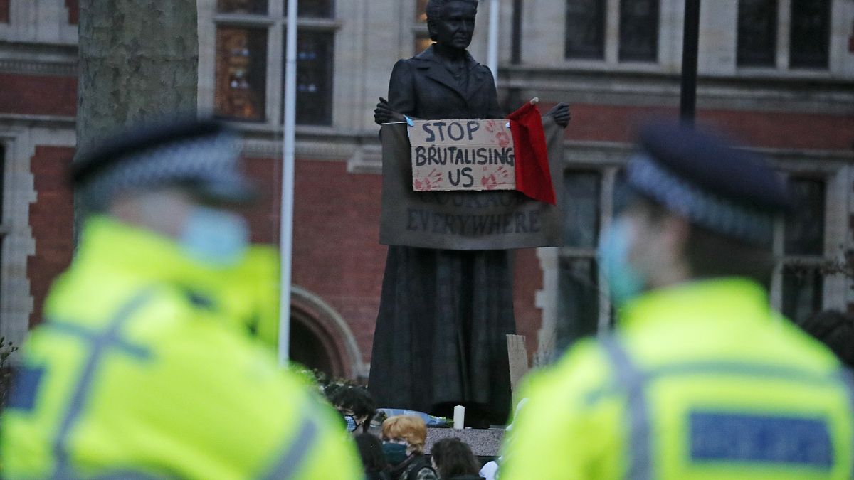 ضابشا شرطة ينظران إلى لافتة معلقة على تمثال ميليسنت غاريت الداعمة لحقوق المرأة خلال تجمع متظاهرين في لندن. 2021/03/14
