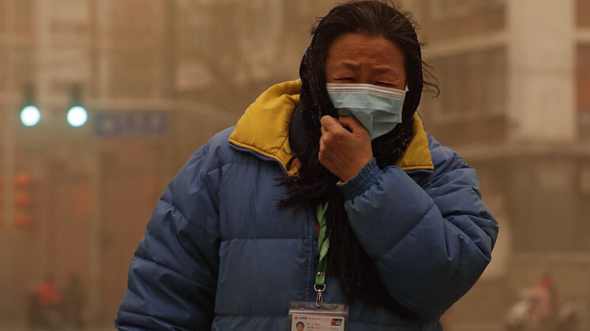 Frau im Sandsturm in China
