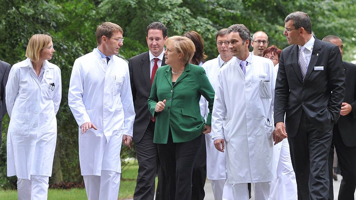 المستشارة الألمانية أنغيلا ميركل تتحدث مع الأطباء أثناء زيارتها لمستشفى سانا في كرمن- شمال شرق ألمانيا.
