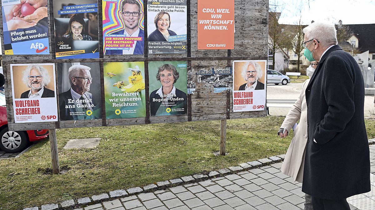 Winfried Kretschmann Baden Württemberg zöldpárti miniszterelnöke a választási plakátokat nézi feleségével