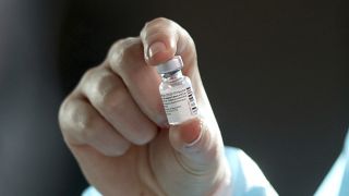 A medical worker in Austria shows Pfizer-BioNTech vaccine.