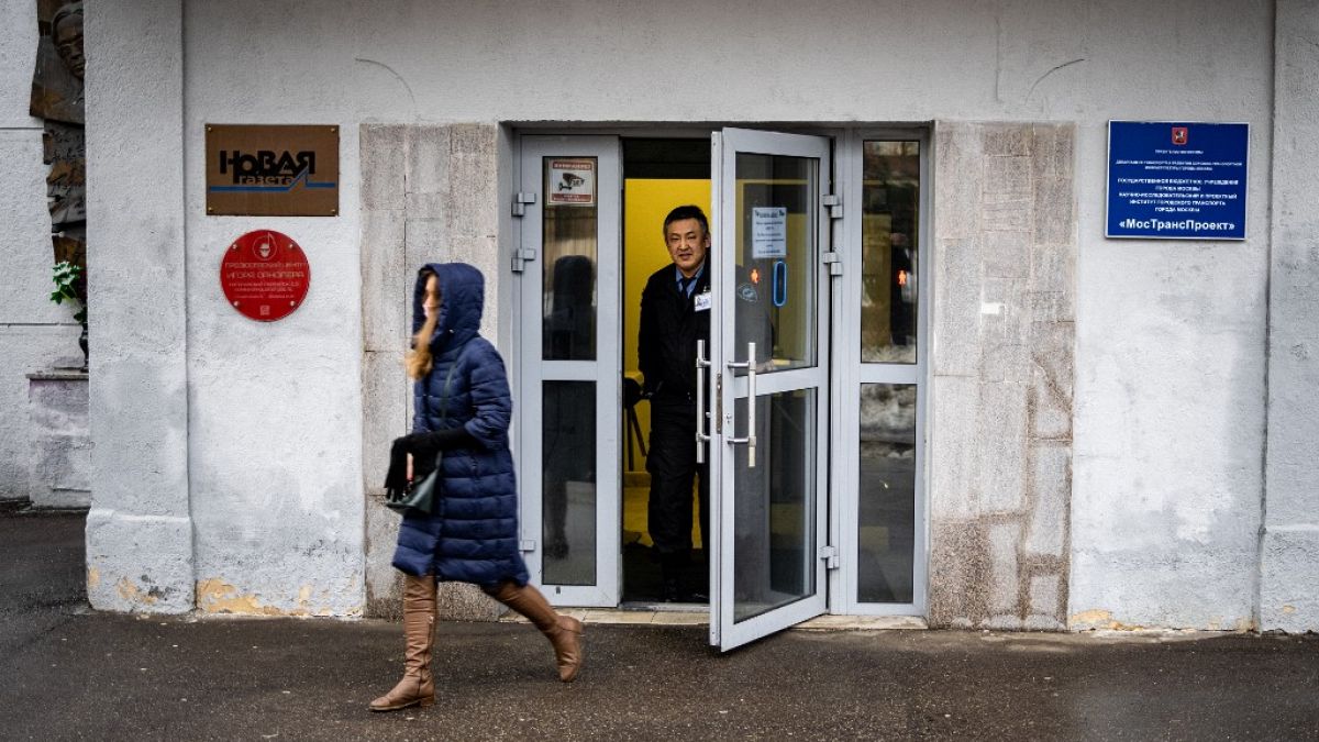 A security guard stands at the door of the building of the editorial office of Novaya Gazeta newspaper in Moscow on March 15, 2021. 
