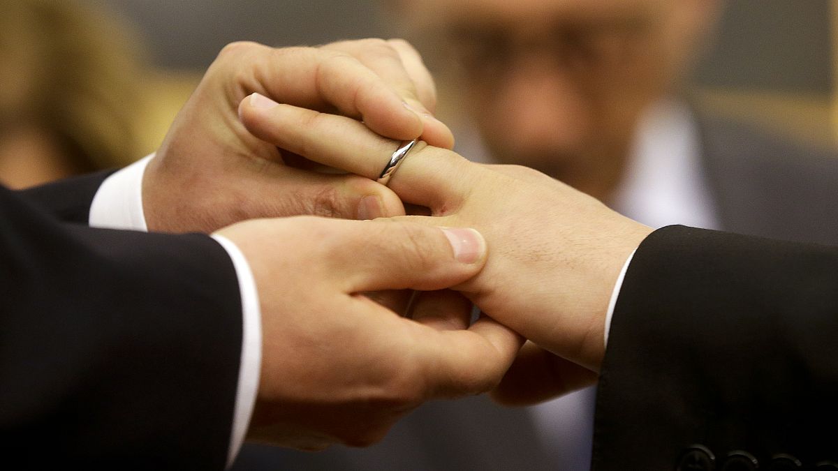 Római pár tagjai húznak jegygyűrűt egymás ujjára élettársi kapcsolatuk bejegyzésekor Rómában 2015. május 21-én