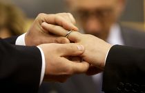 Római pár tagjai húznak jegygyűrűt egymás ujjára élettársi kapcsolatuk bejegyzésekor Rómában 2015. május 21-én