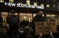 People hold signs outside New Scotland Yard during a march to reflect on the murder of Sarah Everard, in London, March 15, 2021. 