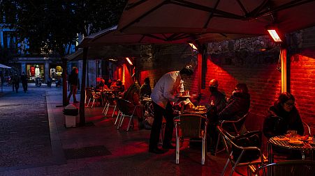 People sit outside at a cafe in Madrid.