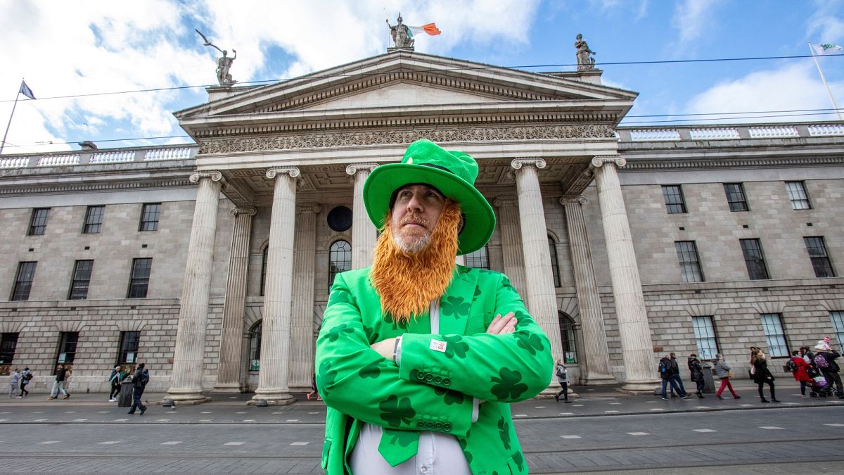A man celebrating St Patrick's Day poses outside the Genearl Post Office (GPO) in O'Connell Street, Dublin on March 17, 2020, as festivities were cancelled due to COVID