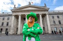 A man celebrating St Patrick's Day poses outside the Genearl Post Office (GPO) in O'Connell Street, Dublin on March 17, 2020, as festivities were cancelled due to COVID