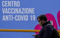 A person walks past a closed vaccination center, in Rome, Tuesday, March 16, 2021
