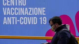 A person walks past a closed vaccination center, in Rome, Tuesday, March 16, 2021