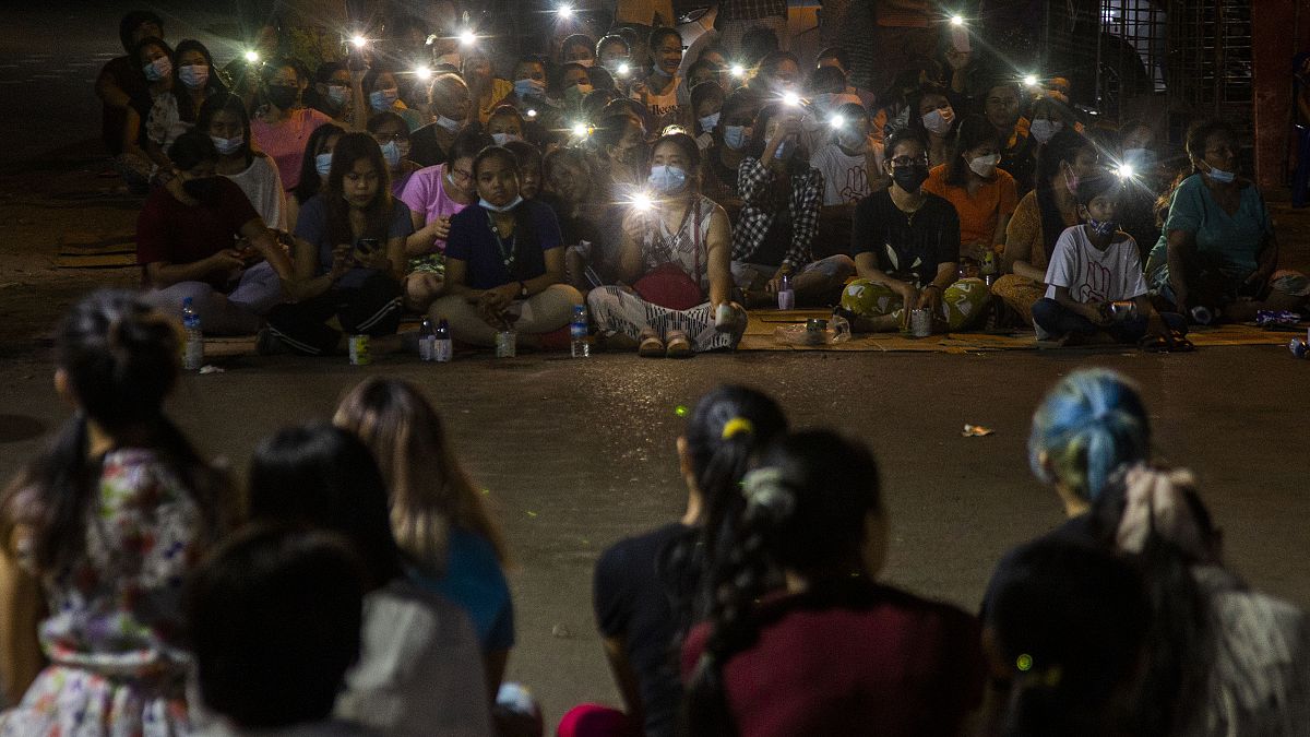 Anti-coup protestors flash lights from their mobile phones during a rally in the Myaynigone area of Yangon.