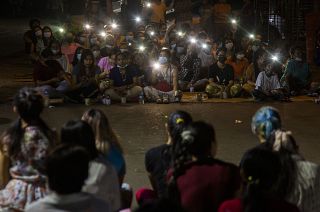 Anti-coup protestors flash lights from their mobile phones during a rally in the Myaynigone area of Yangon.