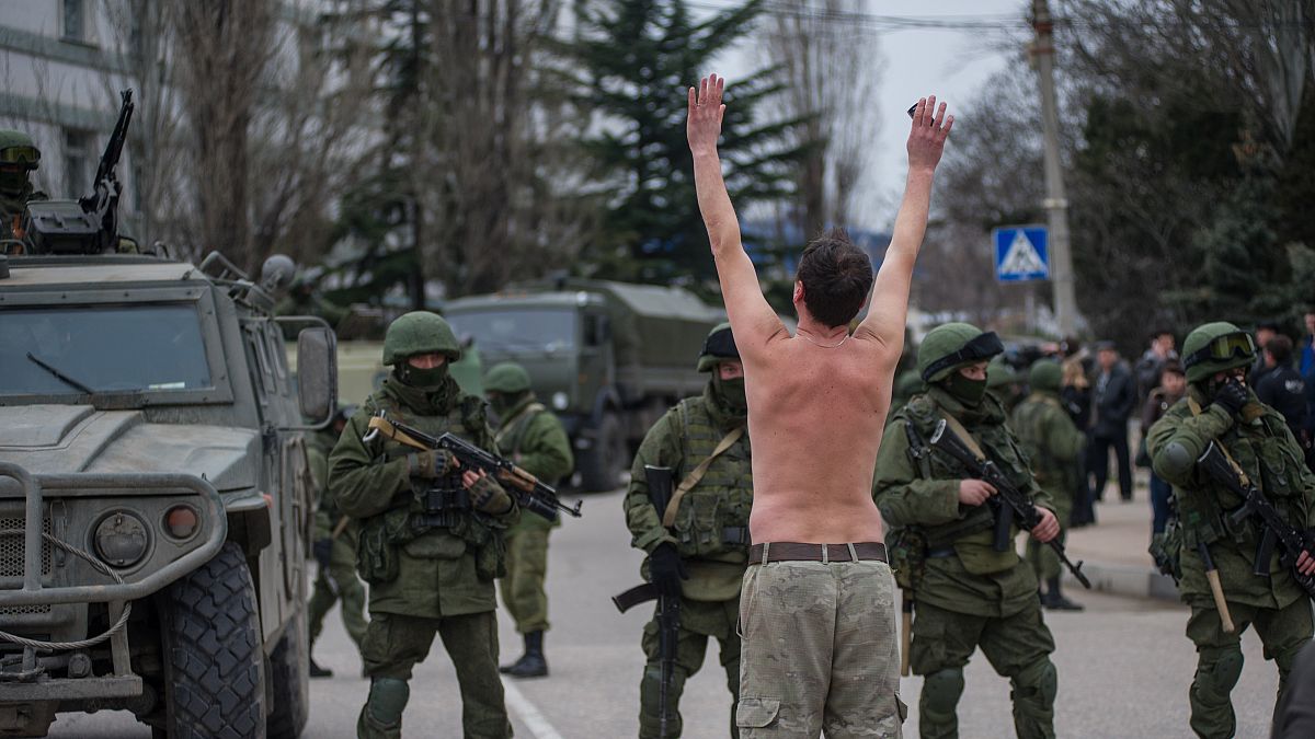 جندي أوكراني في القرم عارياً أمام جنود شاعت تسميتهم بـ"الجنود الخضر" يعتقد أنهم تابعون لروسيا 