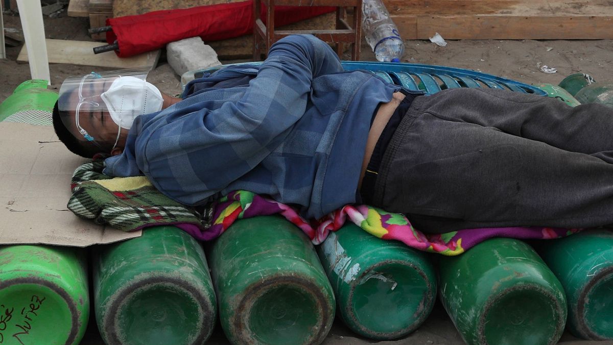 Um homem dorme sobre garrafas de oxigénio, um bem escasso agora no Peru